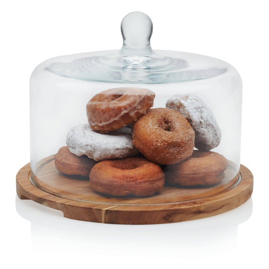 Glass dome with wooden base holding assorted donuts on a white background