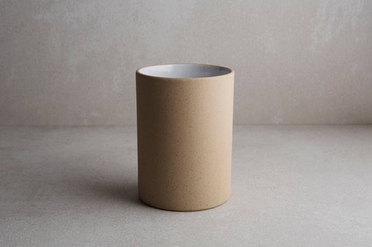 Beige ceramic cup on a plain background