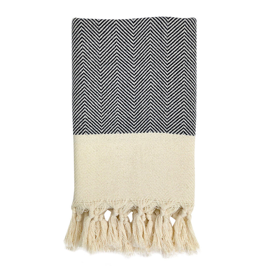 Black and white striped towel with tassels on a white background