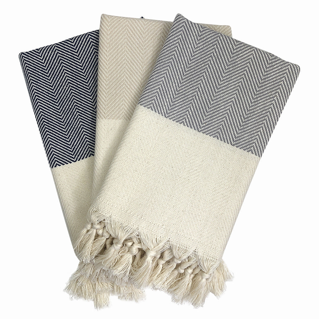 Set of three patterned towels with tassels on a white background