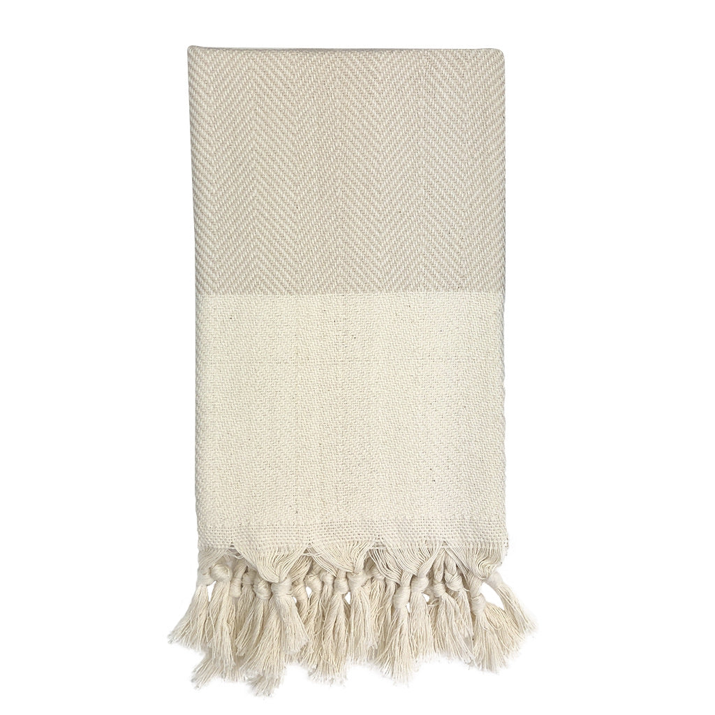 Beige woven blanket with tassels on a white background